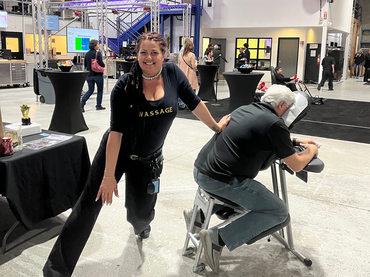 Namaste Skincare & Wellness owner and operator Tisha John with her mobile massage table at a company event