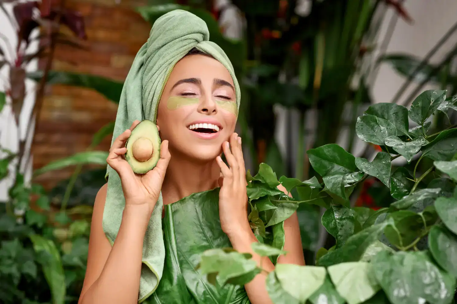 Smiling woman enjoying a custom facial with an avocado mask, representing Namaste’s holistic skincare treatments in Las Vegas.